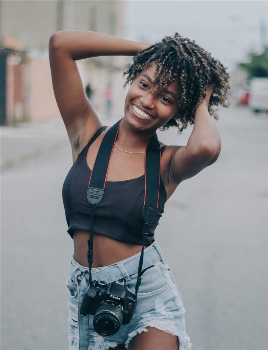 Jovem do Projeto Doulos com câmera fotográfica, representando o protagonismo juvenil em fotografia e vídeo no Instituto Alfa.
